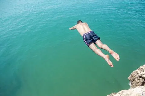 A man diving into the water from a cliff. Foto stock