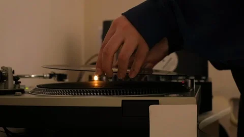 Man dj puts a vinyl record in the player (warm colors) Stock Footage 106026019
