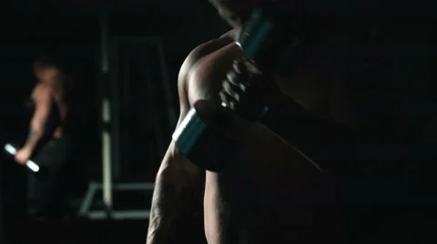 Man do exercises with weights at gym, lowlight, mirror reflection 스톡 동영상 68414669