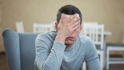 Man do a facepalm at the room Stock Footage 148496420