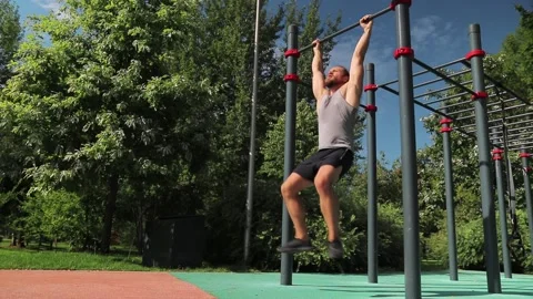 Man do hanging leg raise on the horizontal bar Stock Footage 140137559