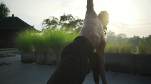 Man do long lunge with twist yoga pose roof with solar battery rapid slow motion Stock Footage 89724304