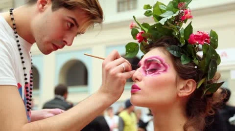 Man do makeup for model with flowers and leaves hair adornment Stock Footage
