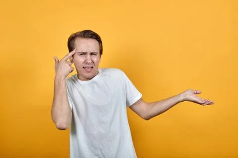 Man do not break shows his finger on a red pimple and direction of hand to side. Stockfoto's