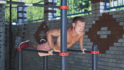 Man do push ups on parallel bars Stock Footage 255888788