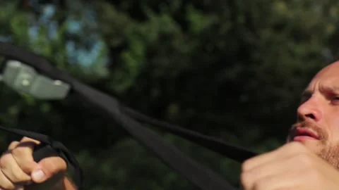 Man do reverse push-ups on playground among trees total body resistance exercise 動画素材 139398140