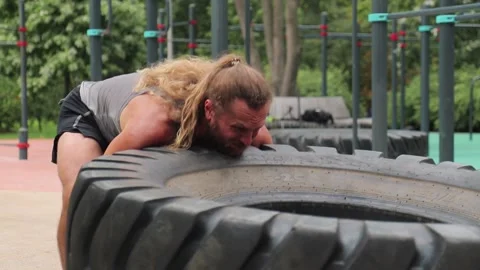 Man do tire lifting exercise Stock Footage 147076847