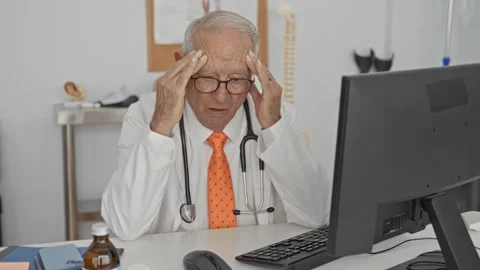 Man doctor holding temples with hands at computer desk with stethoscope and.. Stock Footage 337376912