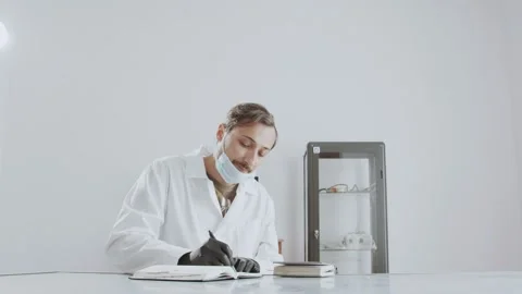 A man doctor writes in a diary and tells instructions on taking medications Stock Footage 239609469
