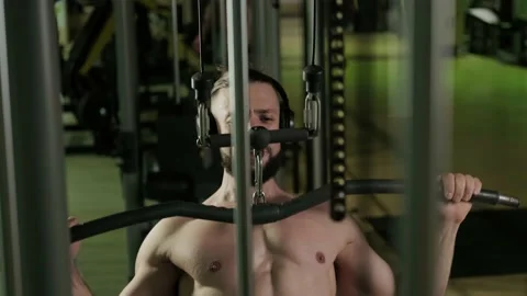 A man does a back exercise on a equipment. Gym training, sports Stock-Footage 234326545