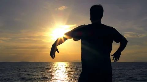 Man does breathing exercise alone at sunset Stock Footage 81180170
