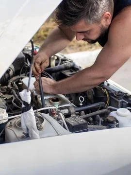 A man does a broach of the head. Makes car repair, engine malfunctioning 스톡 사진