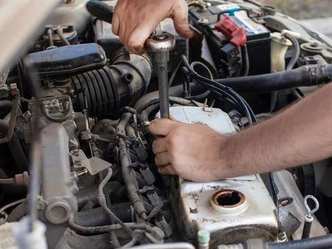 A man does a broach of the head. Makes car repair, engine malfunctioning 스톡 사진