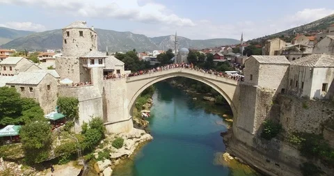 A man does a cannonball jump off the crowded Mostar Bridge in Mostar, Bosnia. Stock-Footage 129447059