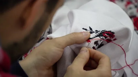 A man does the cross-stitch the wedding towel with a red thread. 動画素材 143025965
