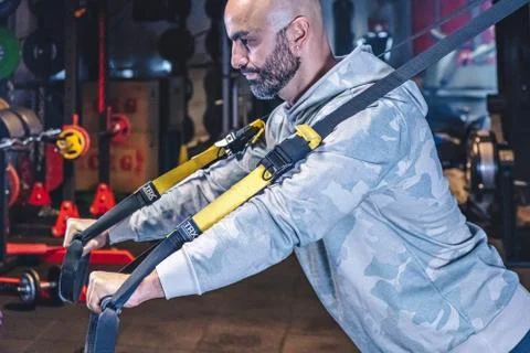 Man Does Crossfit exercise With Trx Fitness Straps In Gym Stock Photos