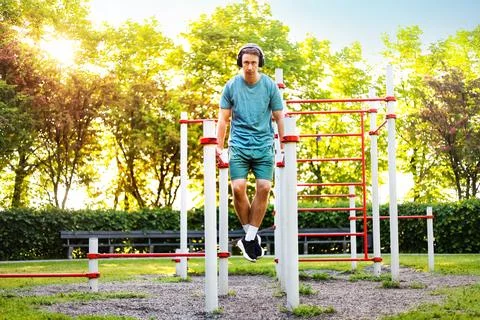 A man does a dip exercise during an outdoor calisthenics workout. Fitness, .. Foto stock