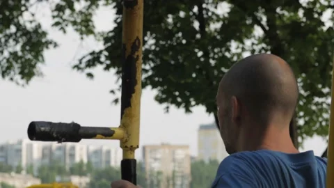 A man does an exercise for the pectoral muscles on a street sports simulator. Stock Footage 157861265
