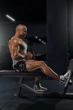 A man does an exercise pulling a block to a belt while sitting Stock Photos