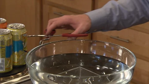 Man does an experiment where a soda can crushes due to change in air pressure Stock Footage 99047453