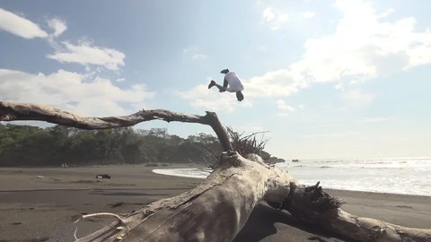 Man Does Front Flip Off Beach Log in Slow Motion Stock Footage 87723437