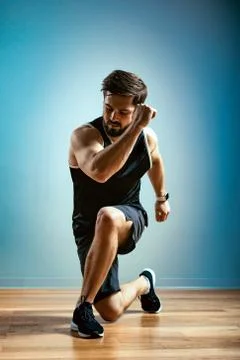A man does functional exercises in the gym on a gray background. Fitness concept 库存照片