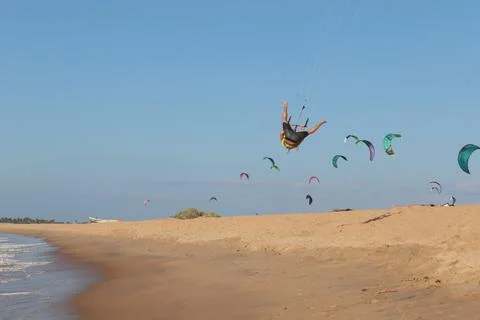 Man does funny things with the kite. Hang gliding Stock Photos