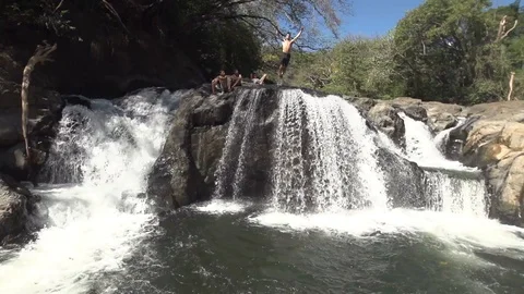 Man Does Gainer Flip Off of Waterfall in Slow Motion Stock Footage 87723790