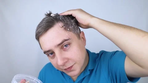 Man does head scrub. Dark-haired young man applies a scalp scrub to combat dandr Stock Footage 256218717