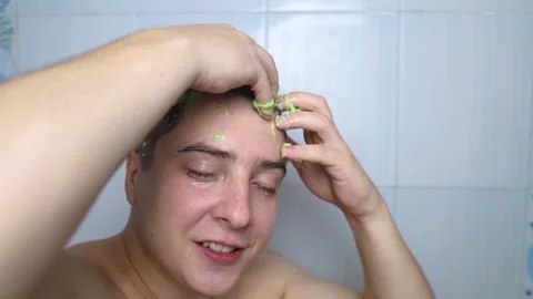 Man does head scrub. Dark-haired young man applies a scalp scrub to combat dandr Video stock 256218754