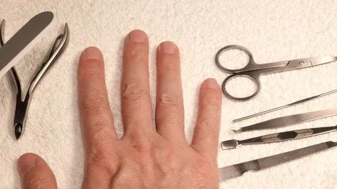 A man does himself a manicure using a nail file. Manicure process UHD 4K video f Stock Footage 77330565