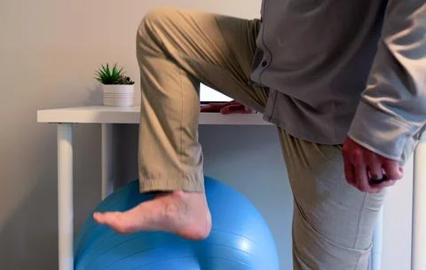 Man Does IT Band Physical Therapy at Standing Desk Stock Photos