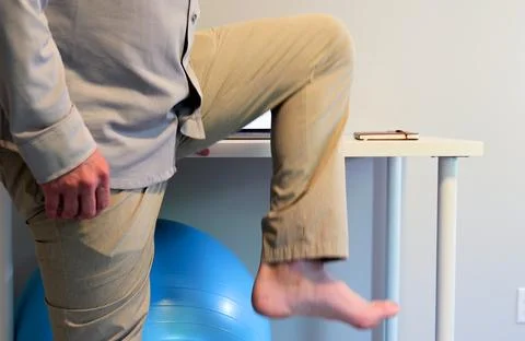 Man Does IT Band Physical Therapy at Standing Desk Stock Photos