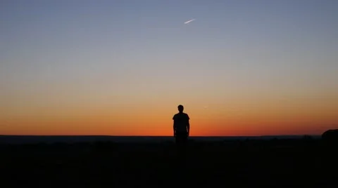 Man does jumping jacks while the sun sets in the background. Stock Footage 54516116
