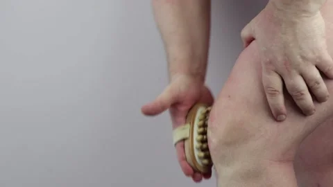 Man does a knee massage with a massage brush Stock Footage 151590343
