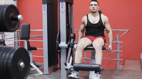 Man does leg extensions Stock Footage 63388944