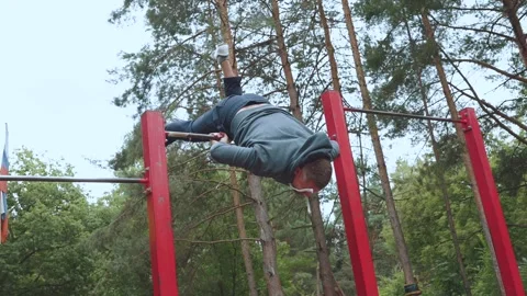 A man does a lift-flip on a horizontal bar Stock Footage 247547458