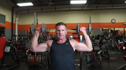 Man Does Military Shoulder Press With Dumbbells Vídeos de archivo 61576748