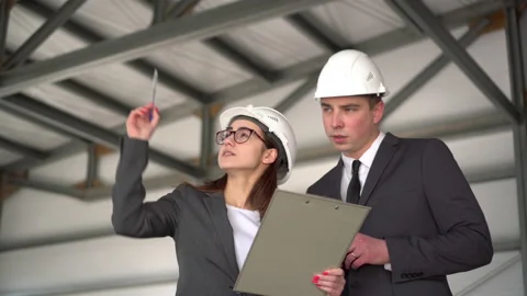 The man does not approve the project. Young man and woman in helmets with Stock Footage 134270209
