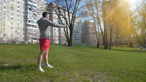 Man does physical exercise on grass in park Video stock 120133905