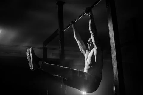 The man does pull-ups on the crossbar. Black and white Stock Photos
