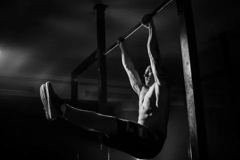The man does pull-ups on the crossbar. Black and white Stock Photos
