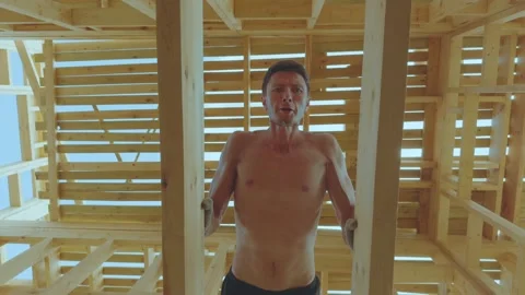 A man does push-ups in a building under construction Stock Footage 339506603