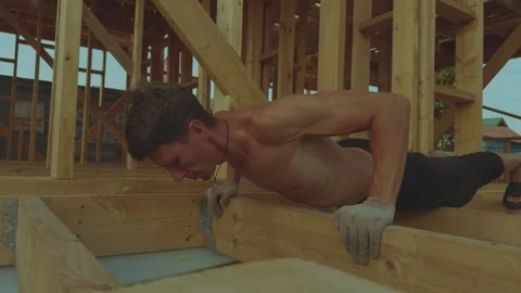 A man does push-ups in a building under construction Stock Footage 340359817