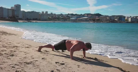 A man does push-ups near the ocean. Stock Footage 171527888