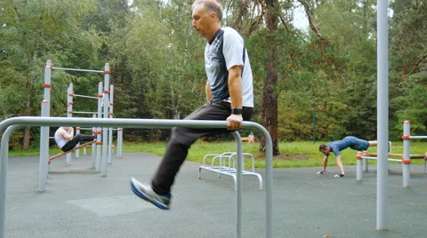 A man does push-ups on parallel bars Stock Footage 66549548