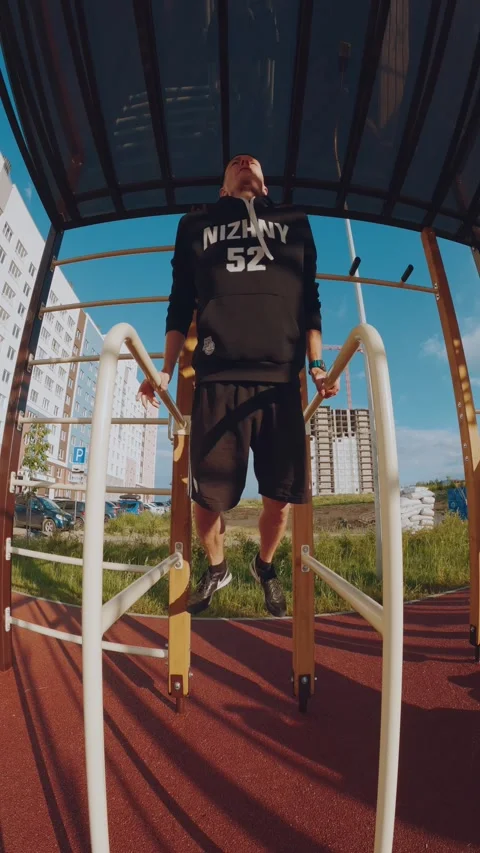 A man does push-ups on the uneven bars, training on the uneven bars Stock Footage 278041508