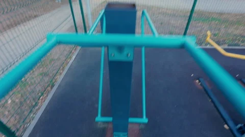 A man does push-ups on the uneven bars on the playground. Stock Footage 316844444