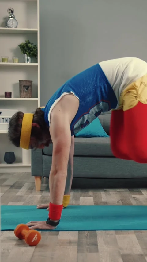 A man does pushups on a yoga mat at home, showing commitment to fitness Stockbeeldmateriaal 310812436