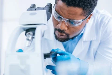Man does scientific research with the microscope in the lab. Stock Photos
